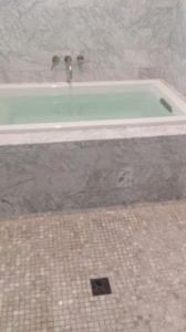 Top mount set in bathtub in marble base